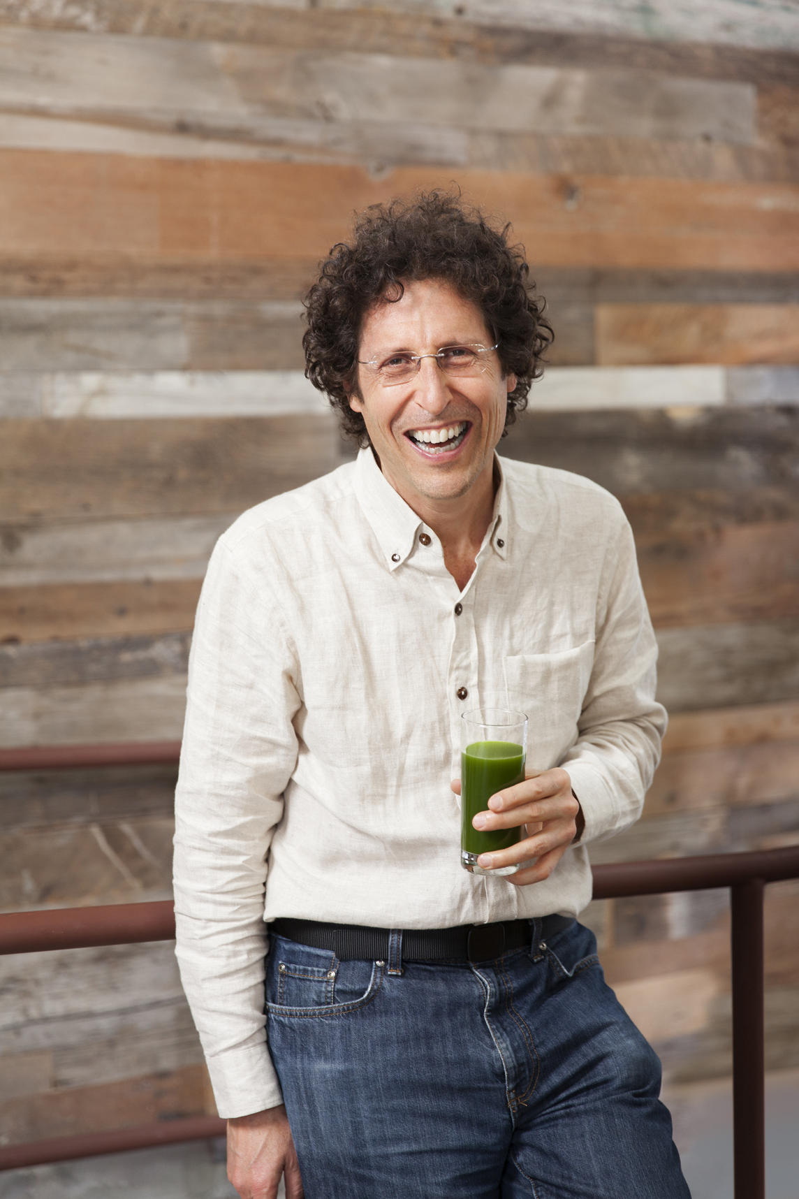Doug Evans holding a glass of green juice