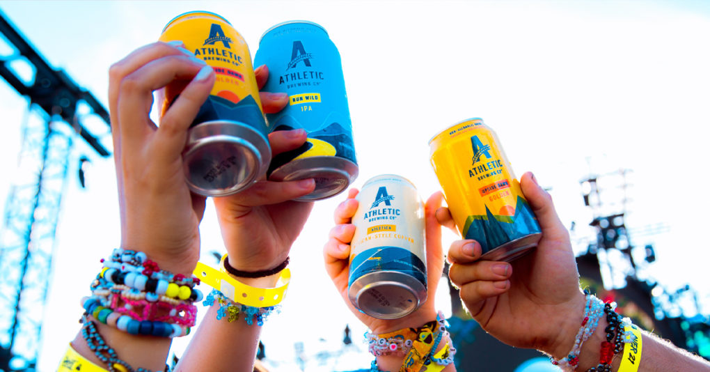 Athletic Brewing cans being held by concert attendees