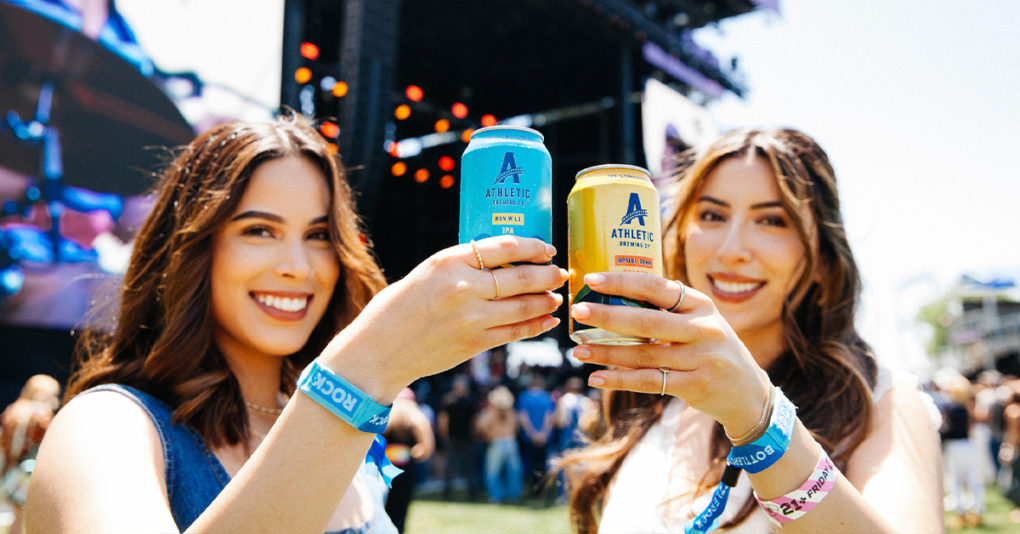 Athletic Brewing cans being held by concert attendees